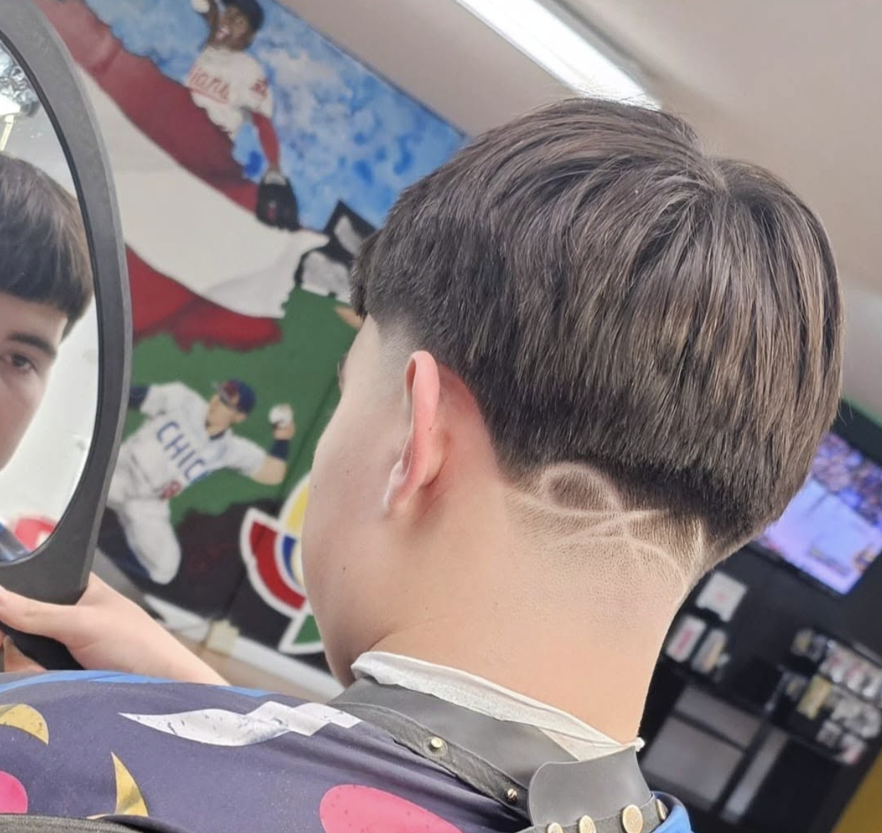 Low taper fade with textured top, cut at Eric's MVP Barber Shop